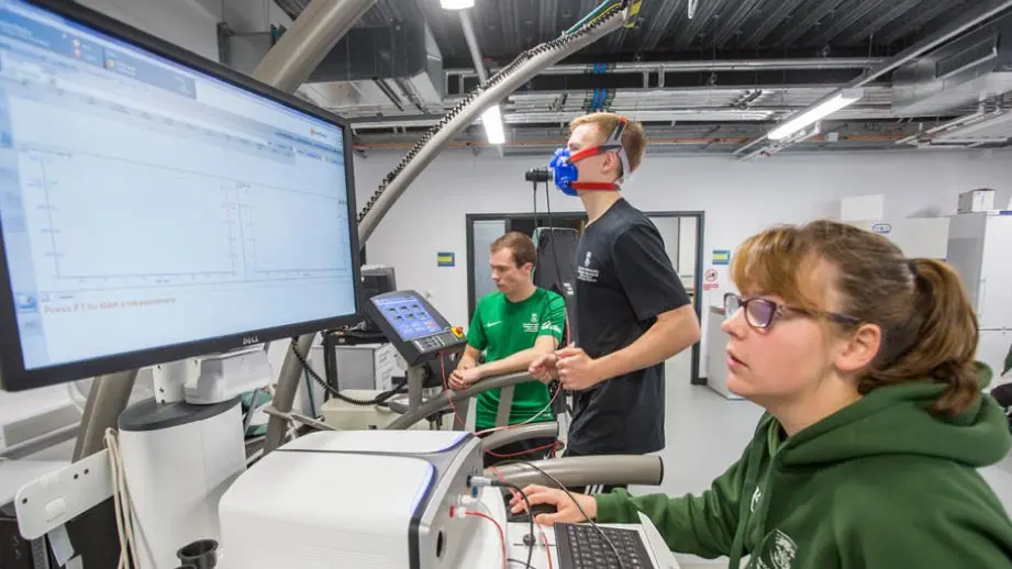 Profesionales del equipo médico realizan mediciones de oxígeno a un jugador corriendo en una cinta.
