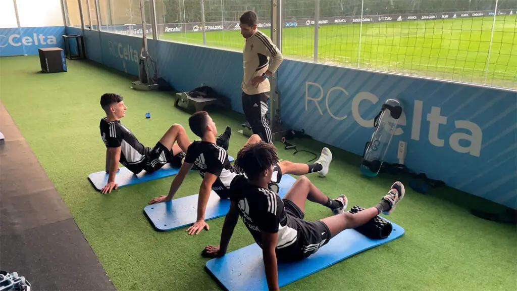 Preparador físico de prácticas trabaja ejercicios de flexibilidad con los jugadores del Celta de Vigo