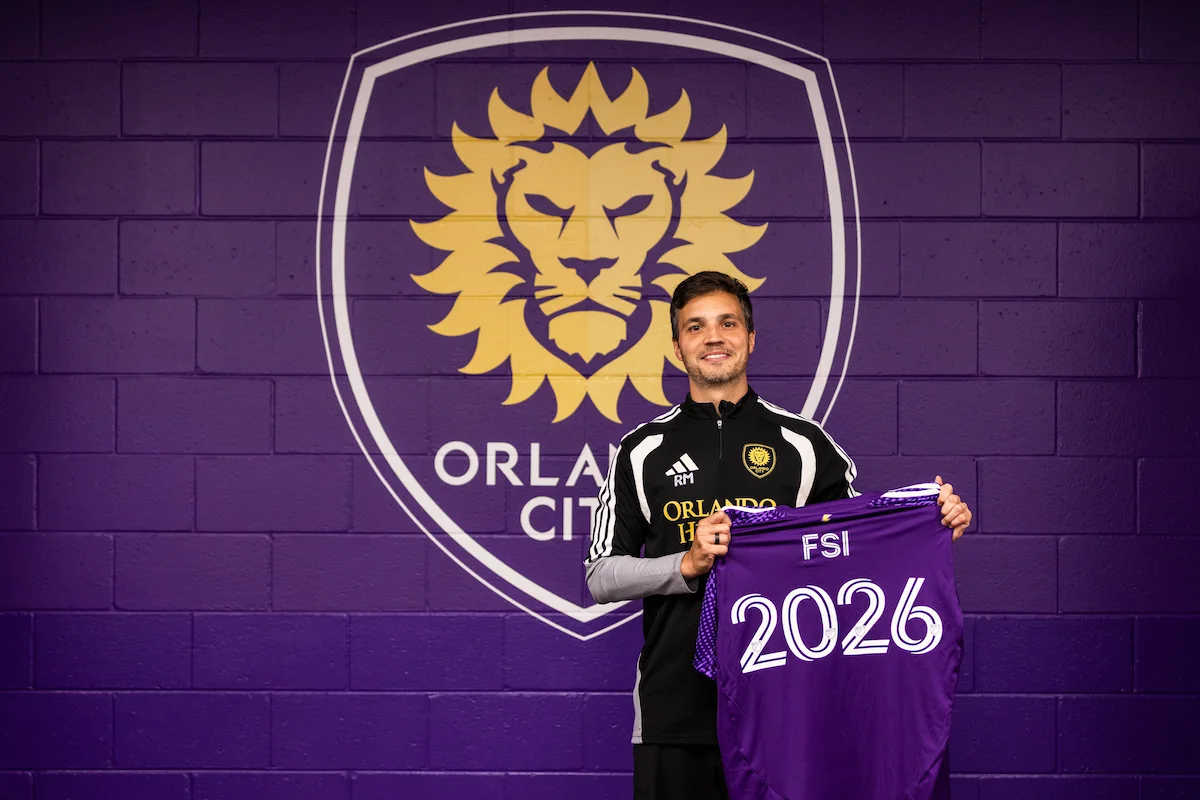 Orlando City SC staff holding an FSI jersey